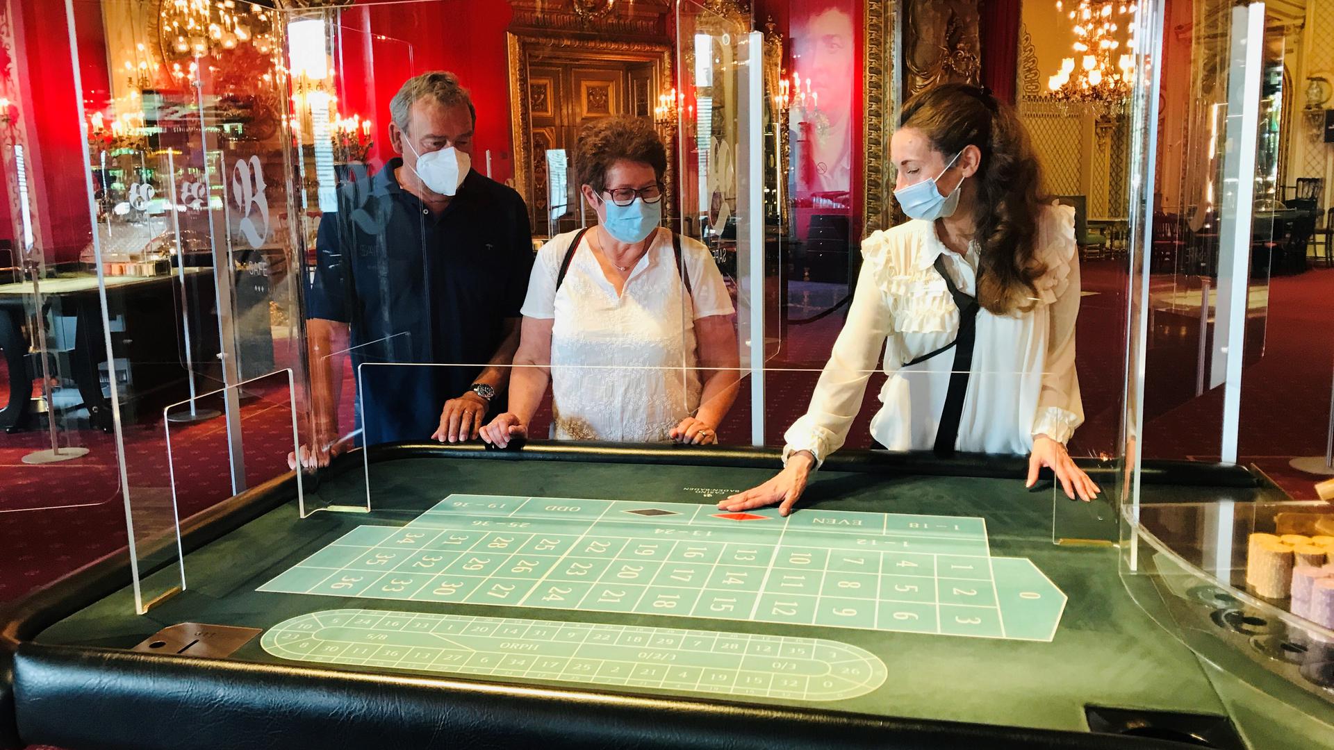 Claudia und Georg Matysczok lassen sich von einer Casino-Mitarbeiterin in das Roulettespiel in der Spielbank Baden-Baden einführen.