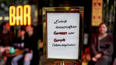Vor einer Bar im Hamburger Stadtteil St. Georg steht ein Hinweisschild, welches auf den Einlass nach der 2G-Regel hinweist.