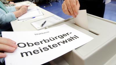 Eine Wahlurne und ein Stimmzettel für die OB-Wahl