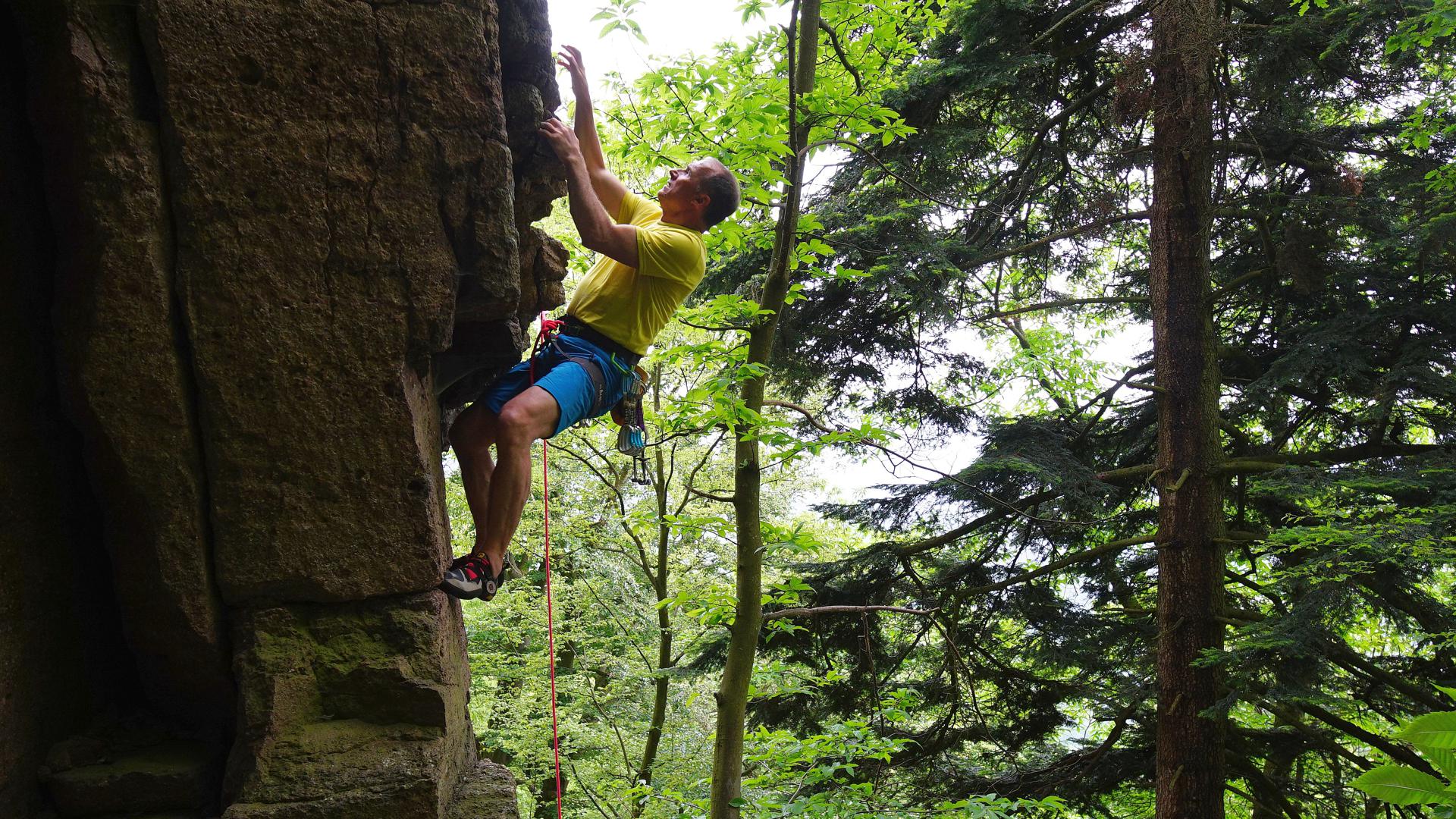 Bergsteiger Ralf Dujmovits klettert einen Felsen hoch.