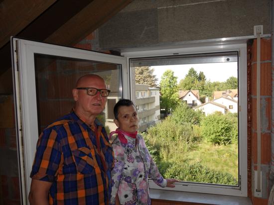 Karin Müller und ihr Partner Roland stehen an ihrem Fenster mit Blick auf das Grundstück nebenan.