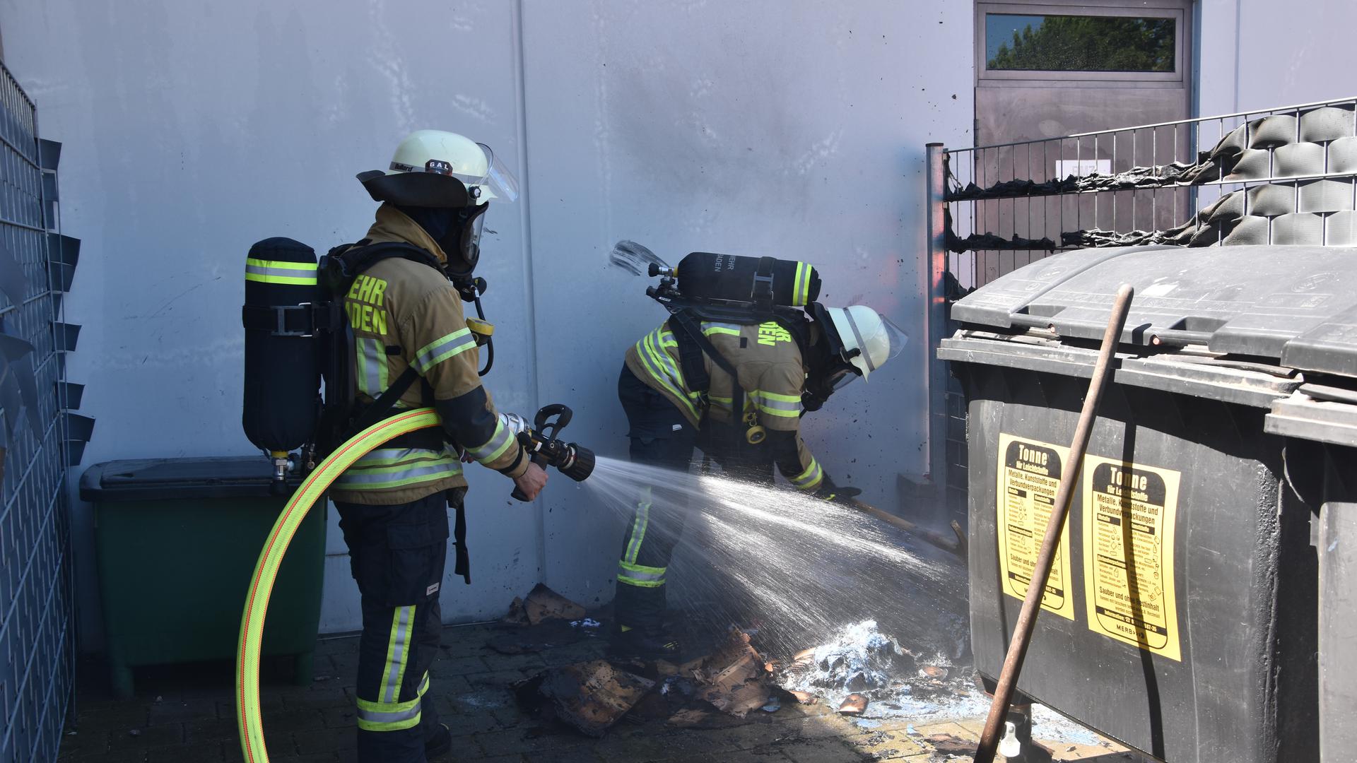 Einsatzkräfte der Feuerwehr Baden-Baden löschen den Containerbrand.
