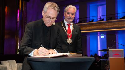 Erzbischof Georg Gänswein (links) trägt sich in Anwesenheit von Oberbürgermeister Dietmar Späth ins Goldene Buch der Stadt Baden-Baden ein. 