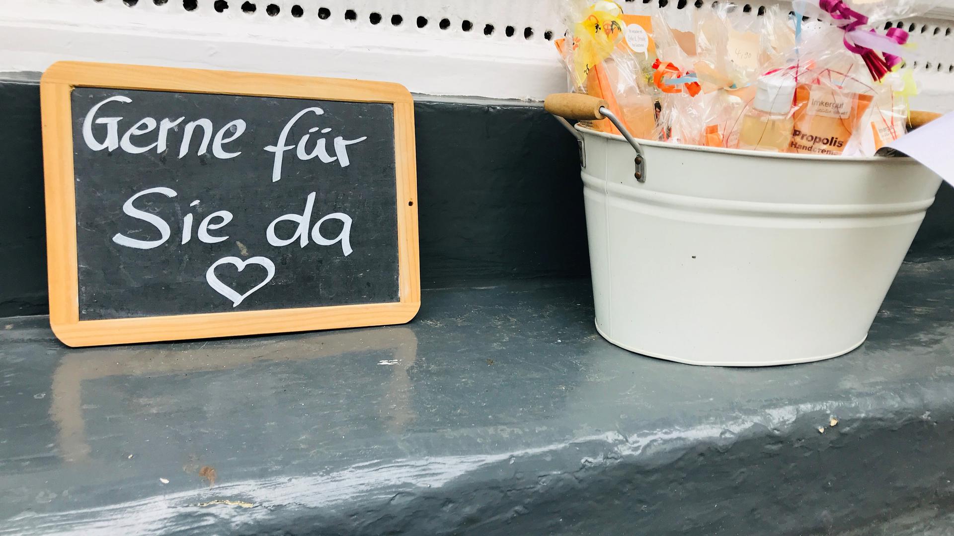 Vor einem Laden in Baden-baden steht eine Tafel mit der Aufschrift „Gerne für Sie da“. 