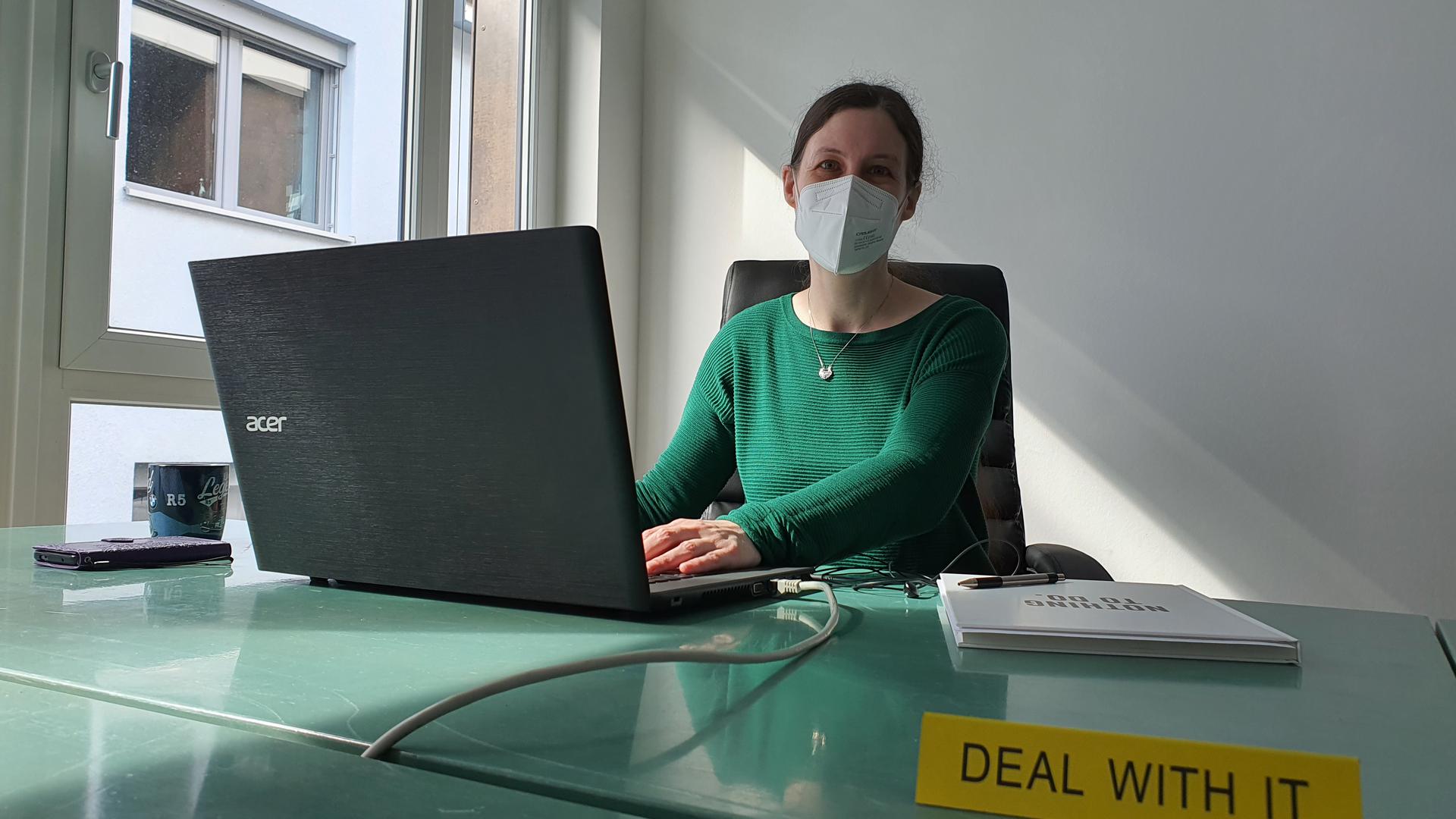 Jennifer Smith sitzt an einem Schreibtisch im Elan Gründerzentrum Baden-Baden. 