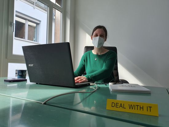 Jennifer Smith sitzt an einem Schreibtisch im Elan Gründerzentrum Baden-Baden. 