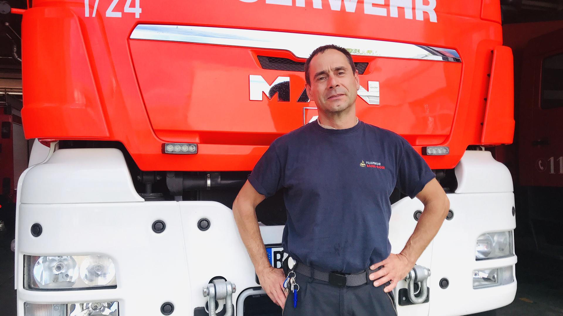 Hauptbrandmeister Christian Frank steht vor einem Löschwagen der Feuerwehr Baden-Baden