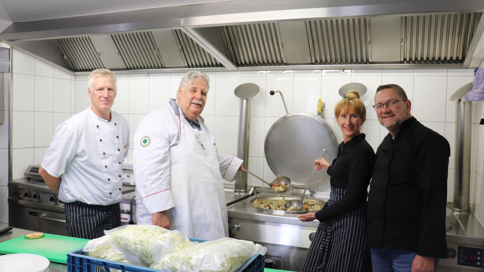 Mitglieder des Kochvereins vor den riesigen Suppentöpfen in der Küche des Pädagogiums in Baden-Baden