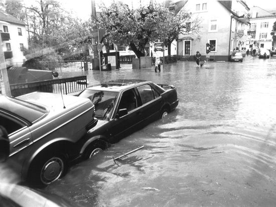 Ineinandergeschobene Autos auf einer überfluteten Straße