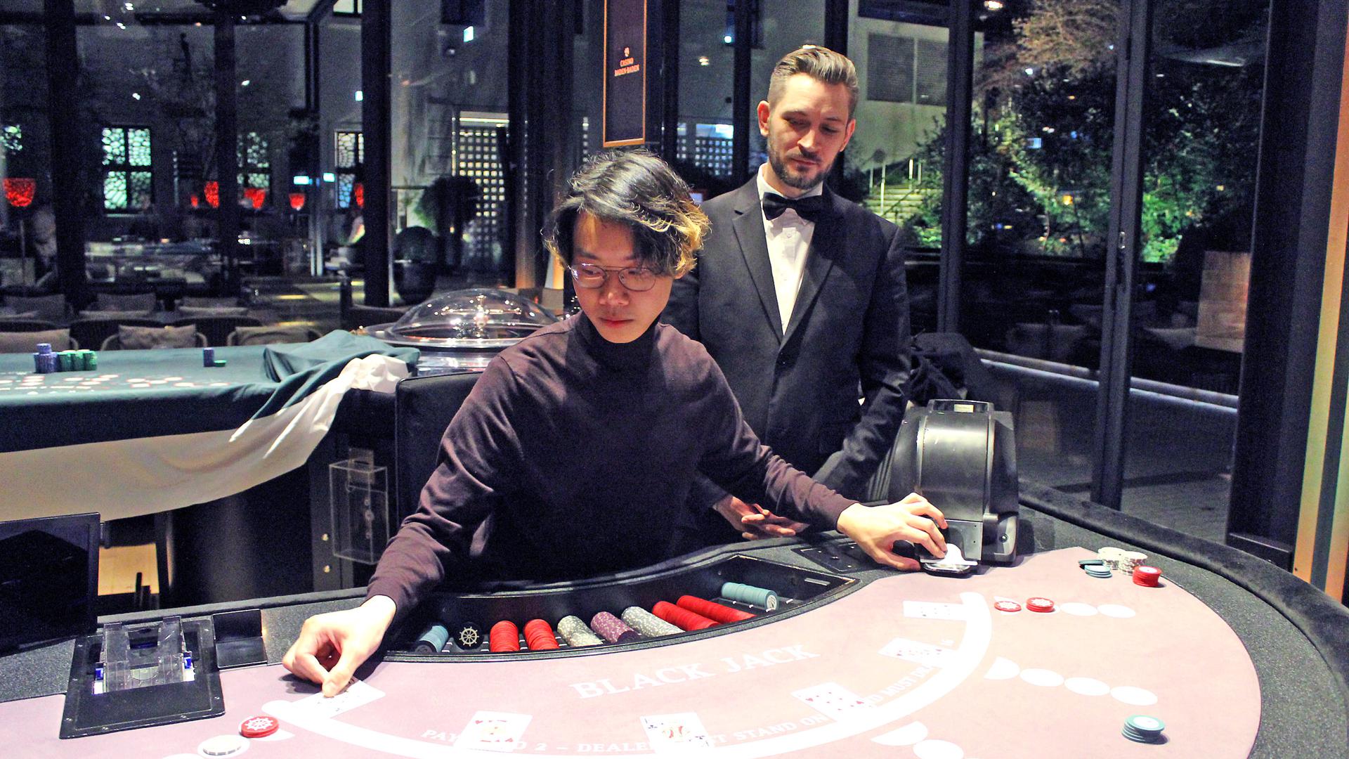 Lukrativer Nebenjob im Casino: Mathematik-Student Huy Tran aus Baden-Baden absolviert gerade einen Kartenspielkurs im Casino. Ausbilder Alexander Clappier schaut ihm am Black-Jack-Tisch über die Schulter.