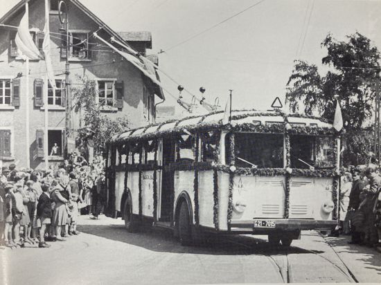 Ein geschmückter O-Bus wird von Menschen bejubelt.
