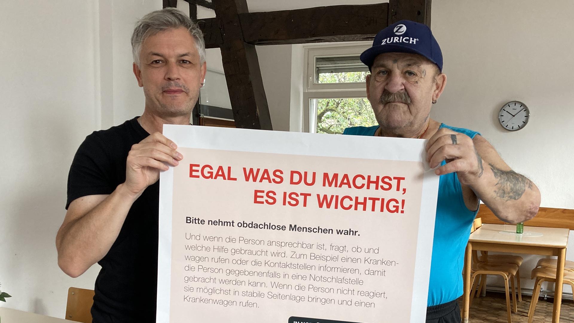 Christian Frisch und Karl-Heinz Lerche halten das Plakat der Kälteschutzaktion in der Hand.