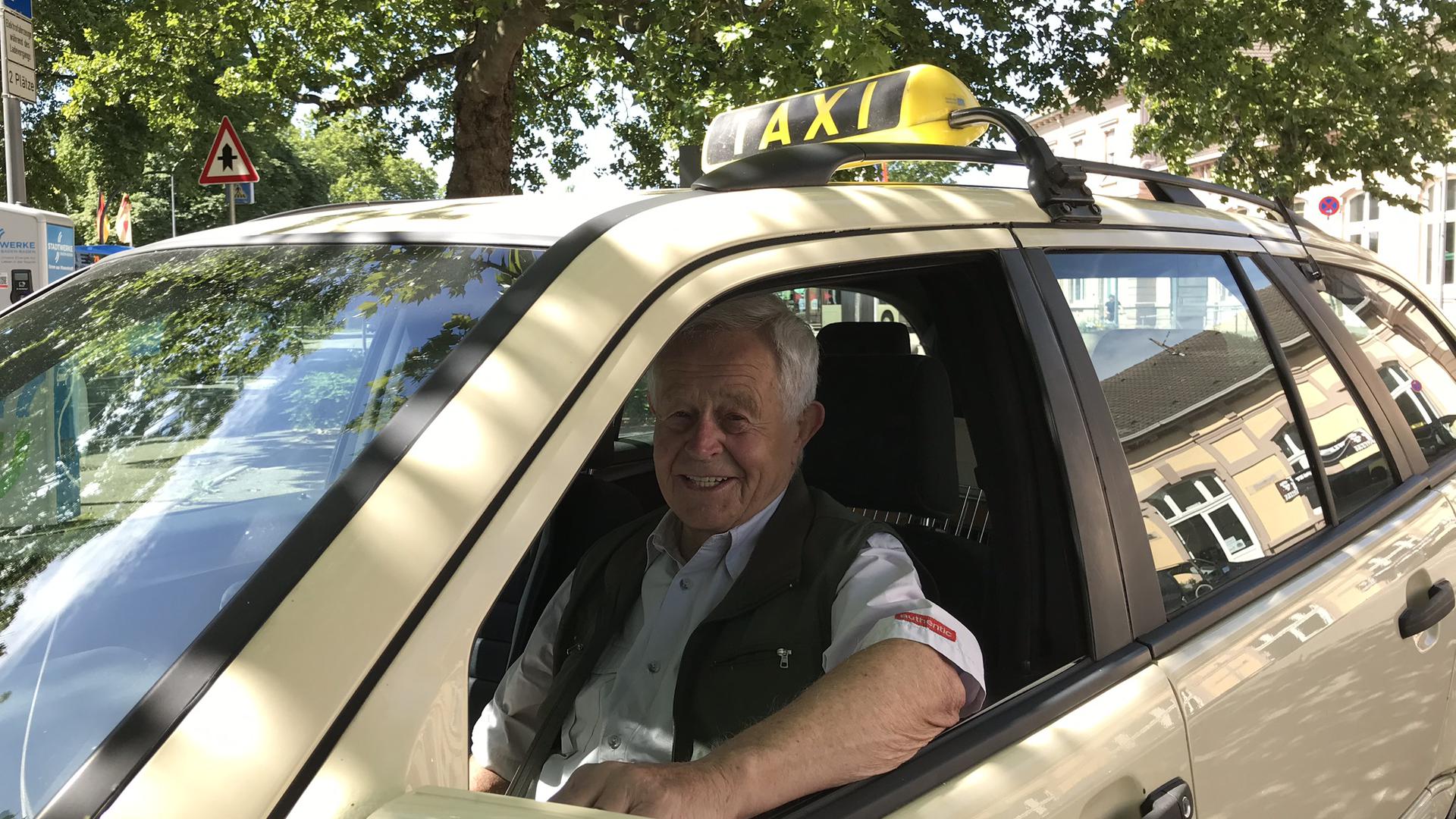 Hans Wiegner sitzt in seinem Taxi.