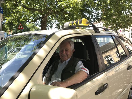 Hans Wiegner sitzt in seinem Taxi.
