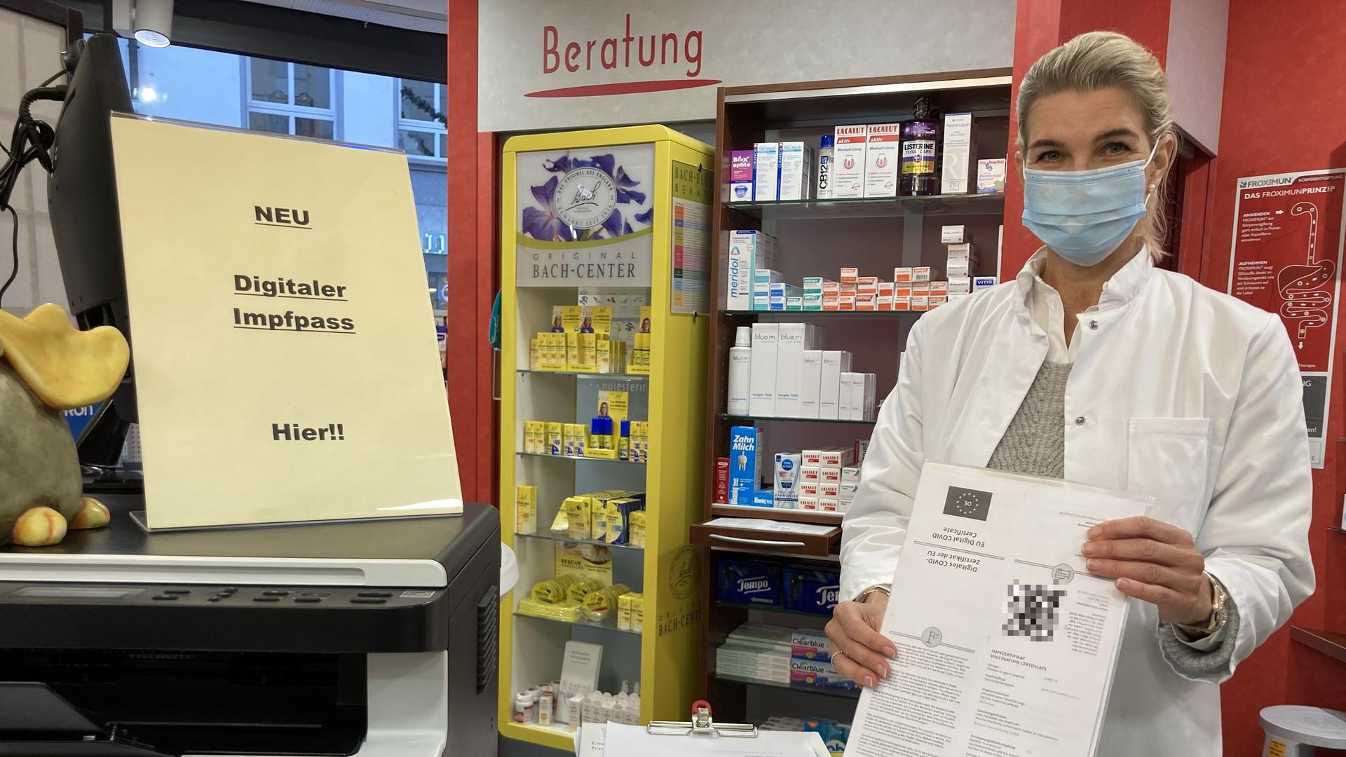 Sandra Hoff steht mit einem digitalen Impfnachweis in ihrer Apotheke