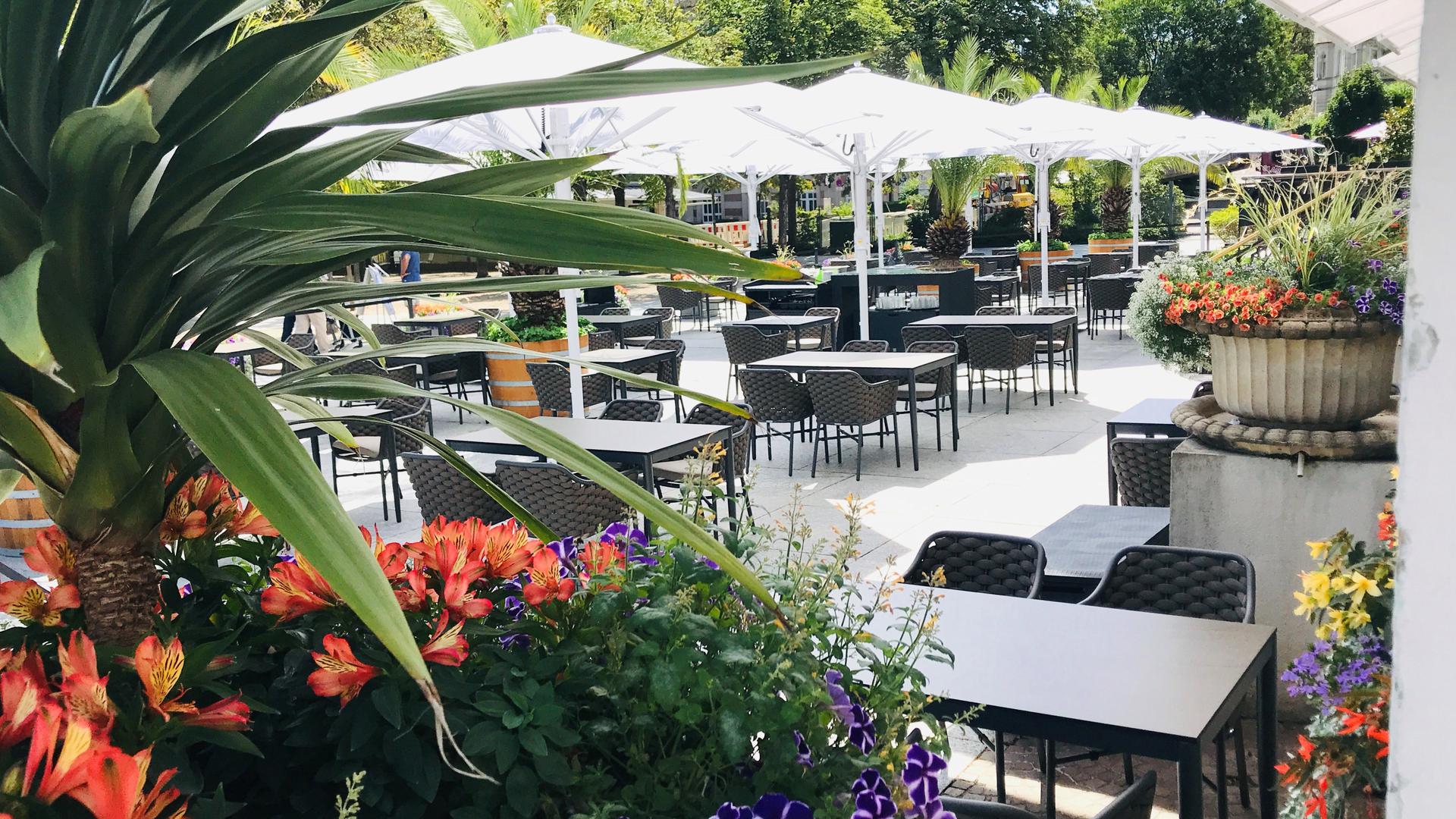 Leere Tische und Stühle sowie Sonnenschirme. Es geht um die Terrasse des Kurhausrestaurants in Baden-Baden