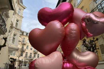 In der Innenstadt von Baden-Baden schweben rosafarbene Herzluftballons.