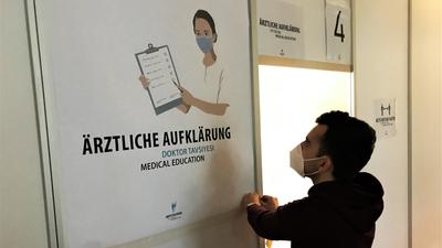Ein Mitarbeiter bereitet im Kurhaus Baden-Baden eine Kabine vor, in der Impfwillige vor dem schützenden Piks ein ärztliches Aufklärungsgespräch erhält.