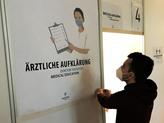 Ein Mitarbeiter bereitet im Kurhaus Baden-Baden eine Kabine vor, in der Impfwillige vor dem schützenden Piks ein ärztliches Aufklärungsgespräch erhält.