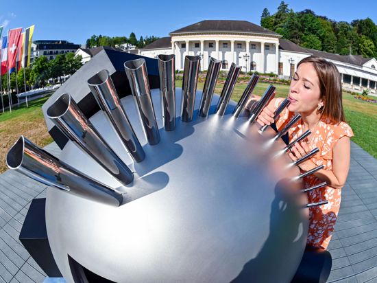 Juliana pustet im Kurgarten Baden-Baden in eine Flöte der Installation «Public Resonator» aus dem Jahr 2023 von Nevin Aladag. Das Werk ist Teil des «Projekts Public Resonator», bei dem der Kurgarten vom 15. Juli bis zum 03. September 2023 in einen «Soundspace» verwandelt werden soll. 