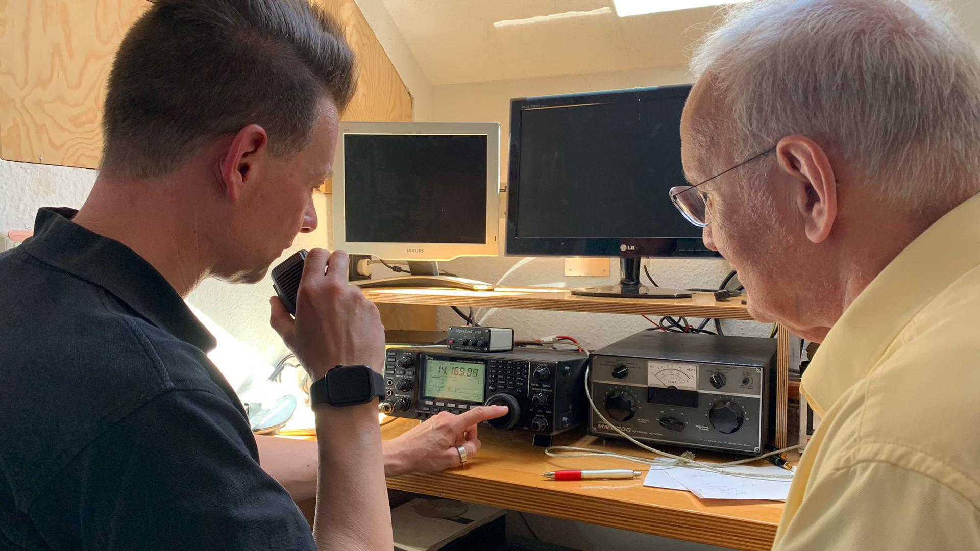 Die Funkamateure Uwe Seiler-Cuesta und Michael Schorradt übermitteln über verschiedene Frequenzen ihr Rufzeichen. Sie hoffen, dass andere Funker darauf reagieren. 