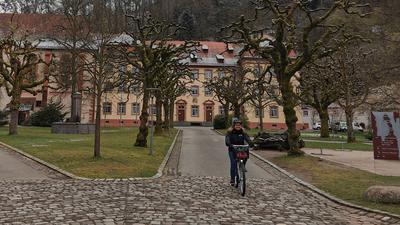 Eine Fahrradfahrerin fährt durch den Innenhof des Klosters Lichtenthal in Baden-Baden.