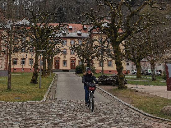Eine Fahrradfahrerin fährt durch den Innenhof des Klosters Lichtenthal in Baden-Baden.