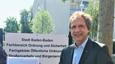Baden-Badens Bürgermeister Roland Kaiser nimmt eine Unterschriftenliste entgegen.,