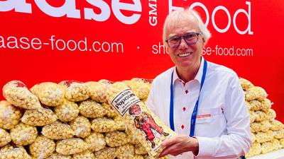 Helmut Haase zeigt am Stand seiner Firma auf dem Kinokongress in Baden-Baden ein Tüte Popcorn. 