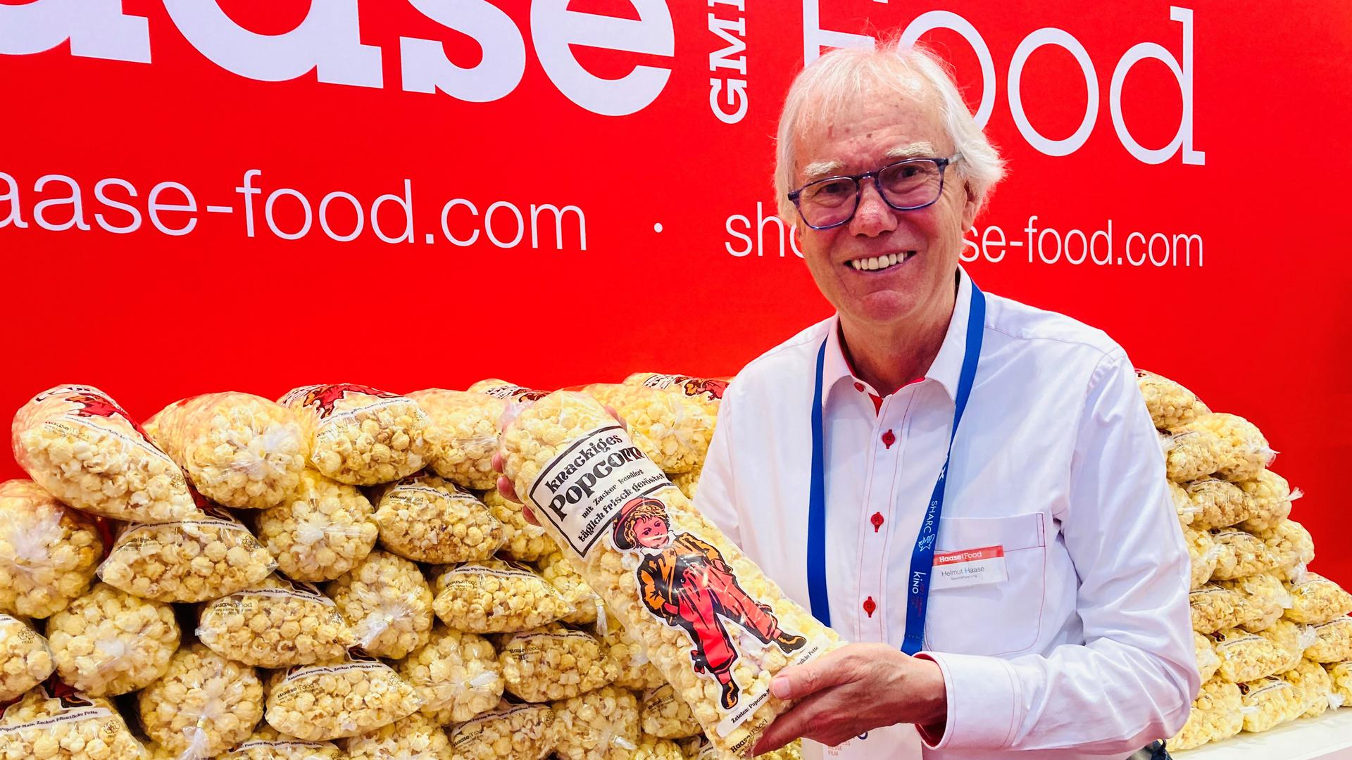 Helmut Haase zeigt am Stand seiner Firma auf dem Kinokongress in Baden-Baden ein Tüte Popcorn. 