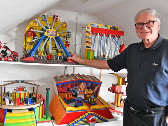 Miniaturmodellbauer Bernd Kleinkopf steht vor einem Regal mit seinen Werken. 