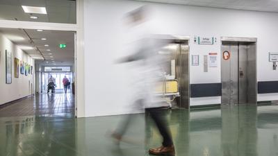 Ein Mann geht durch einen Flur im Foyer eines Krankenhauses