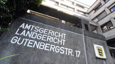 Außenaufnahme des Landgerichts Baden-Baden mit einem Hinweisschild Landgericht, Amtsgericht und dem Landeswappen von Baden-Württemberg. 