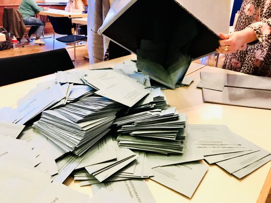 Eine Urne mit blauen Umschlägen mit Stimmzetteln von Briefwählern wird in einem Briefwahlbezirk im Rathaus Baden-Baden auf einen Tisch geleert.