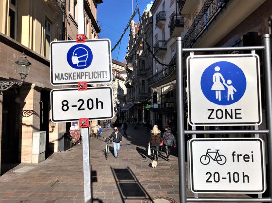 Ein Schild weist auf die Maskenpflicht in der Fußgängerzone Baden-Baden hin.