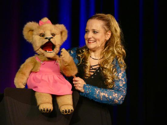 Sabine Murza auf der Bühne  mit einer Löwen-Puppe