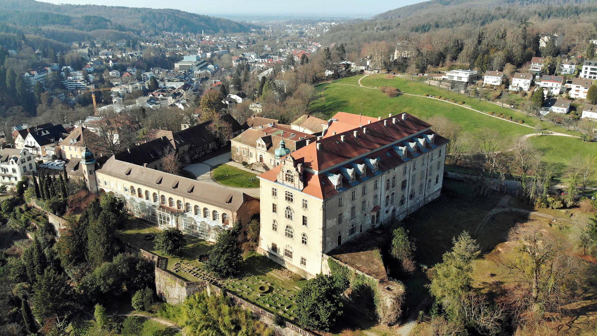 Ein Schloss-Gebäude thront auf einer Anhöhe mit Perspektive in ein Tal.