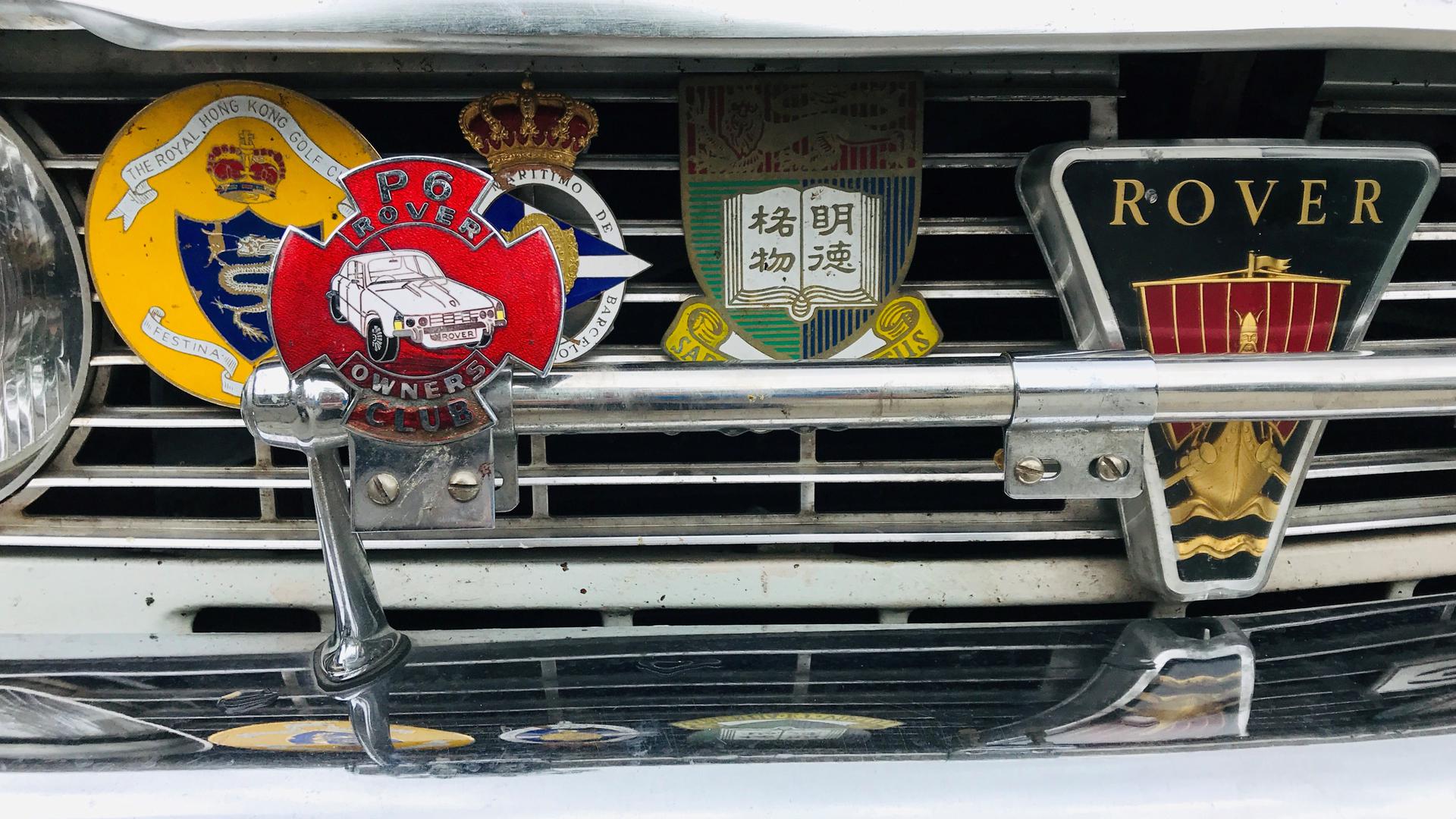 Beim Oldtimer-Meeting 2019 in Baden-Baden steht ein Auto der Marke Rover mit Plaketten verschiedener Oldtimer-Treffen.