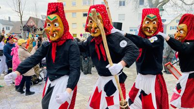 Die Hundsbacher Tannenhexen tanzen beim Umzug in Baden-Oos auf der Straße. 