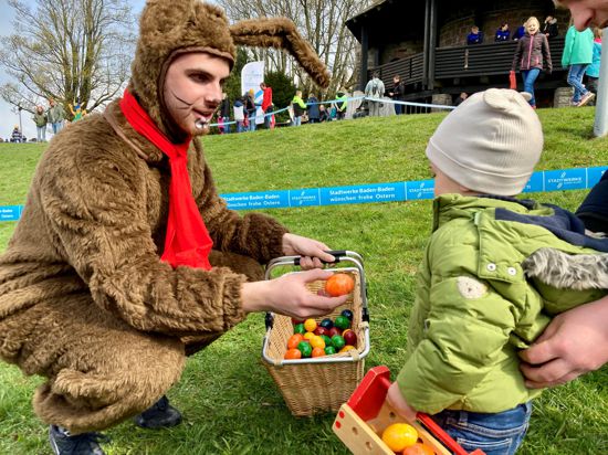 Ein als Osterhase verkleideter Stadtwerke-Azubi verteilt auf dem Merkur in Baden-Baden Ostereier an Kinder.