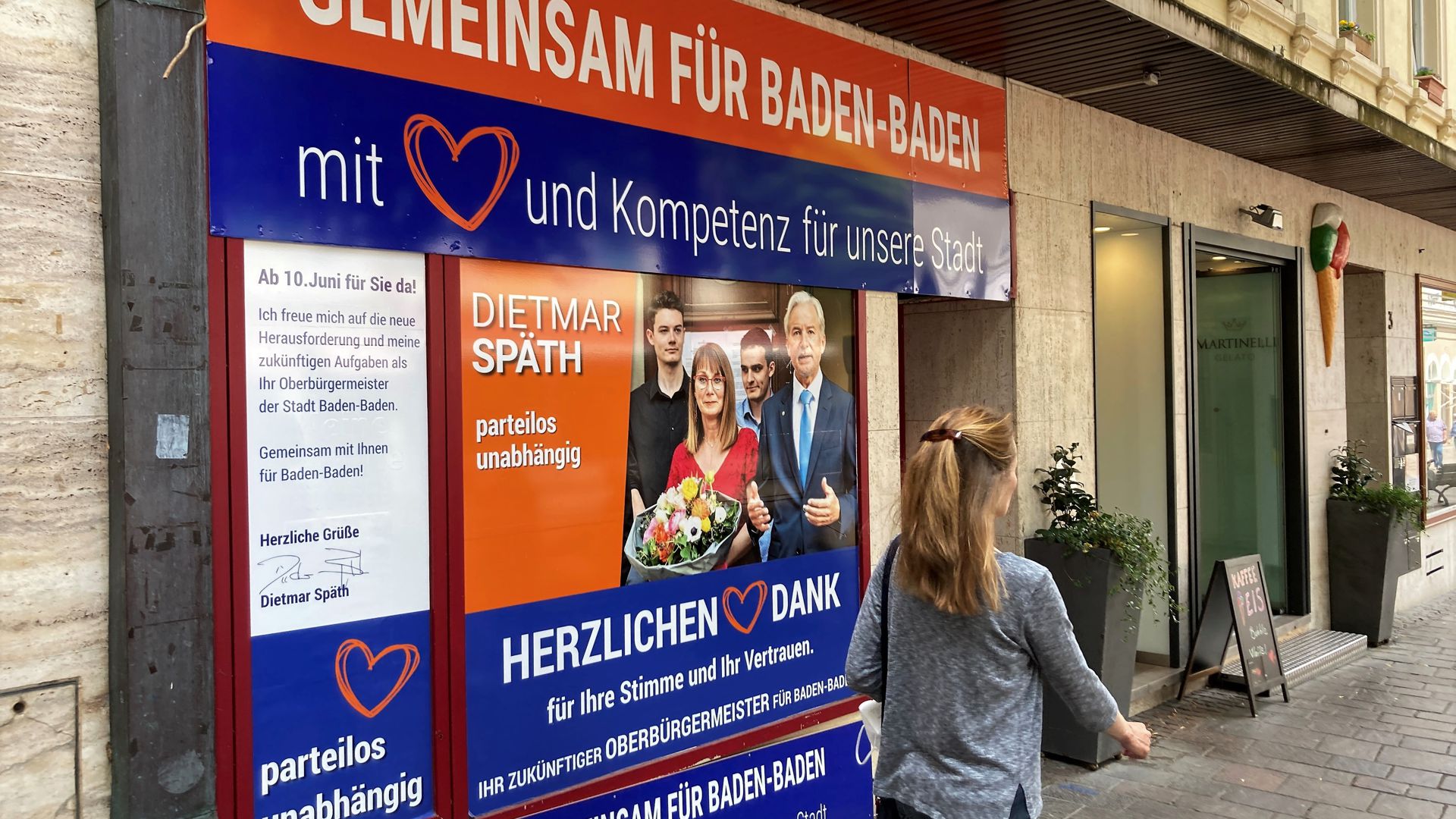 Ein großes Wahlplakat auf einem Schaufenster in der Fußgängerzone Baden-Baden zeigt den neuen OB Dietmar Späth mit seiner Familie.