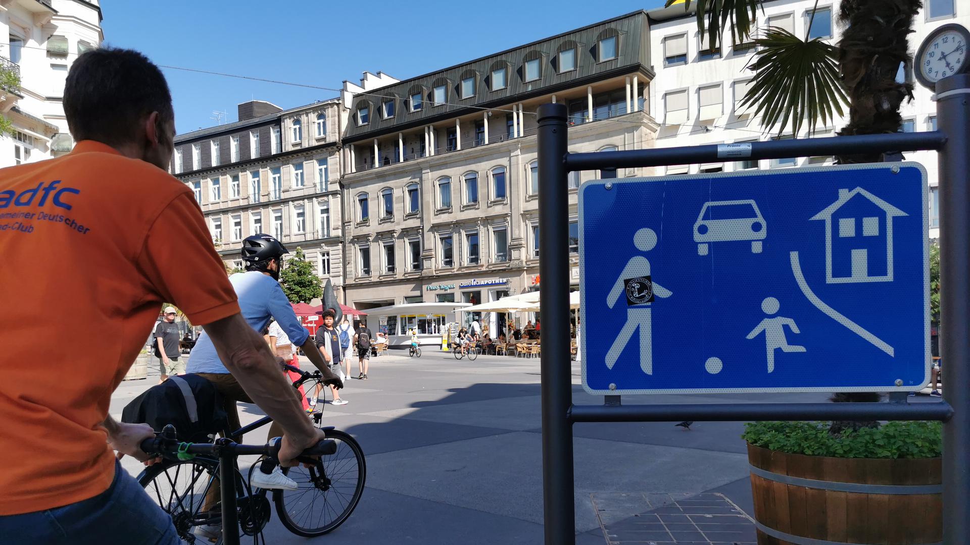 Zwei Radfahrer fahren über den Leopoldsplatz.