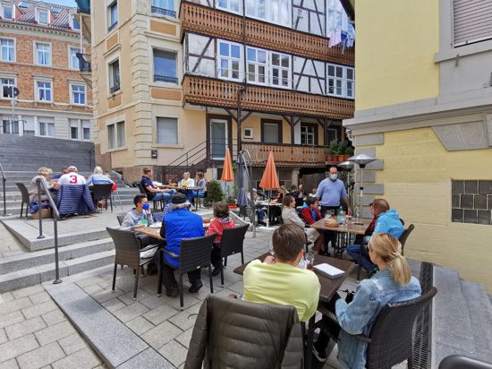 Menschen sitzen auf der Außenterrasse eine Restaurants.