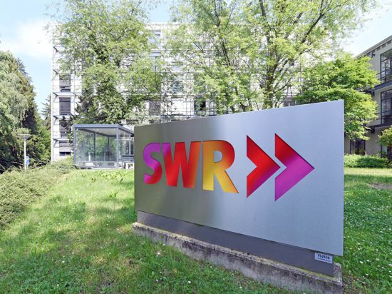 Ein Logo des Südwestrundfunks (SWR) steht vor einem Studioeingang am Standort Baden-Baden.