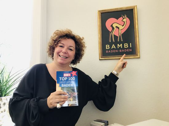 Die Baden-Badener Tourismuschefin Nora Waggershauser steht in ihrem Büro vor dem gerahmten Bambi-Plakat.