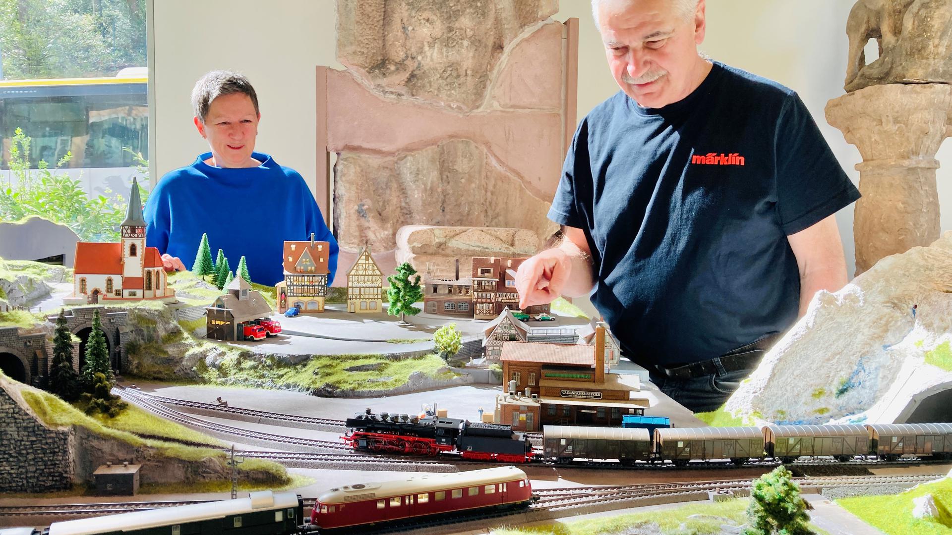 Heike Kronenwett und Walter Schmeiser beobachten fahrende Züge der Modellbahnanlage im Skulpturensaal des Stadtmuseums Baden-Baden. 