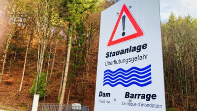  An der Leopoldstraße in Baden-Baden weist eine Tafel auf eine Stauanlage hin. Dahinter verbirgt sich ein Hochwasserrückhaltebecken.