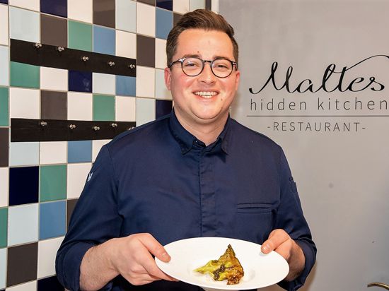 Sterne-Koch Malte Kuhn von Maltes Hidden Kitchen in Baden-Baden präsentiert einen Teller mit Jakobsmuscheln.
