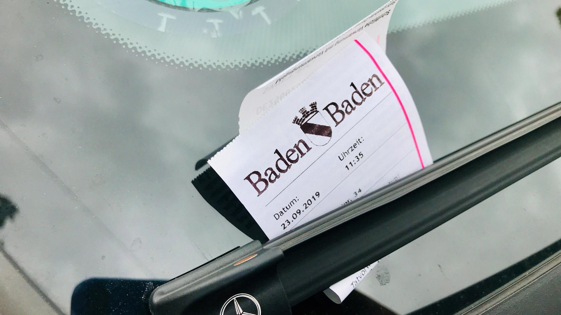 An der Frontscheibe eines Wagens eines Falschparkers in Baden-Baden  hängt ein Strafzettel unter den Scheibenwischer.