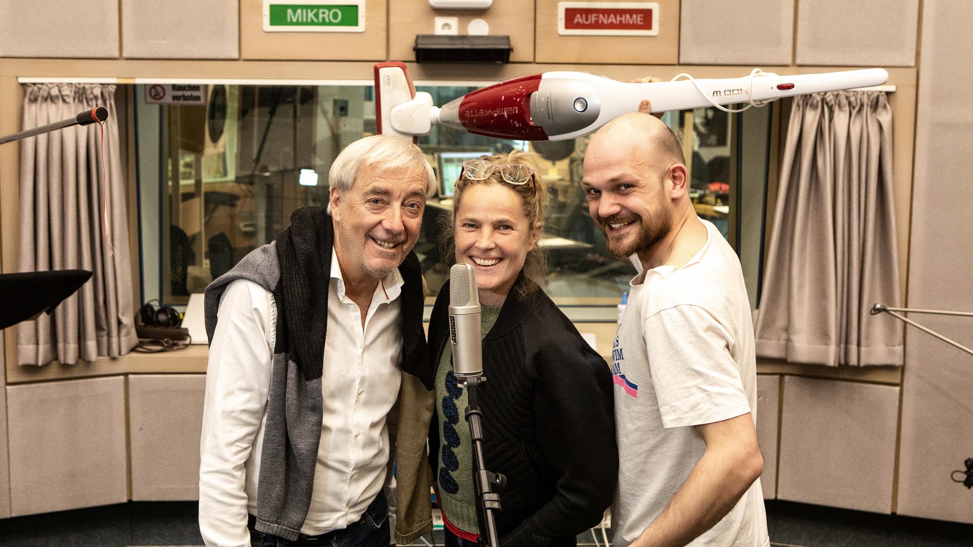 Ueli Jäggi (Xaver Finkbeiner, von links), Karoline Eichhorn (Nina Brändle) und Matti Krause (Sieger) stehen im Hörfünkstudio in Baden-Baden. Sie lösen ihren letzte Fall für den „ARD Radio Tatort“.